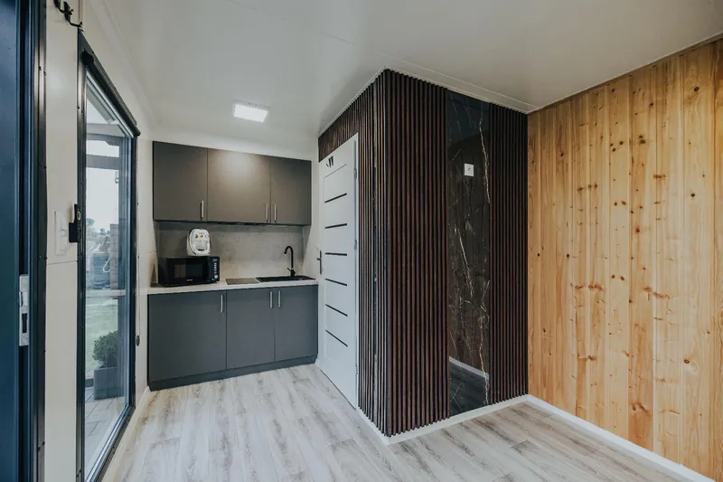 Interior with kitchen units and timber wall